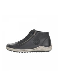 Bottines noires en cuir avec une fermeture éclair latérale, semelle texturée et un détail de logo rond sur le côté extérieur. Caractéristiques d'une semelle claire contrastante.