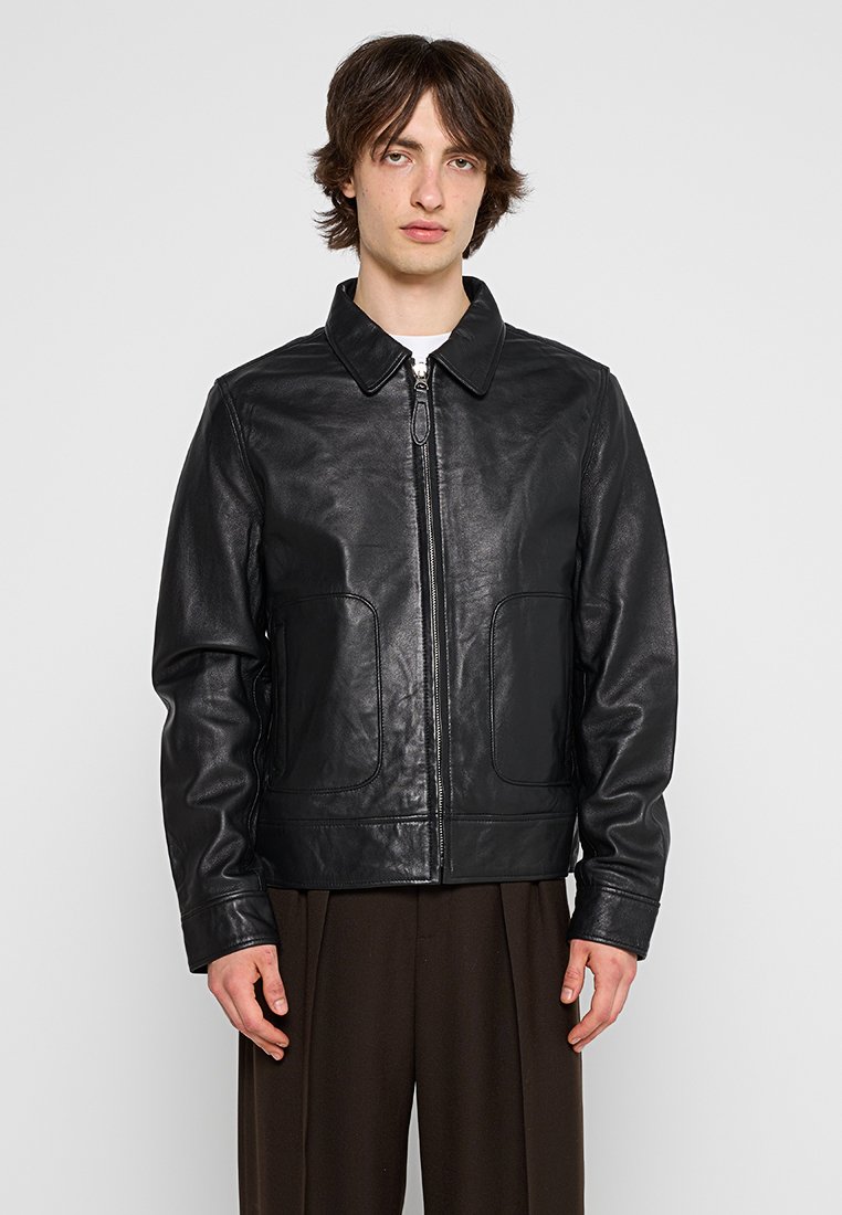 Veste en cuir noir avec col, fermeture éclair et deux poches avant. Texture lisse et coupe ajustée avec un design sobre.