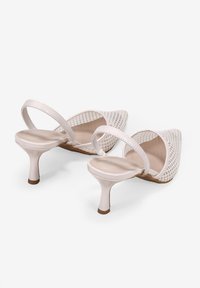 Zart rosa spitze Schuhe mit einem Mesh-Obermaterial und einem schmalen, glänzenden Absatz. Verfügt über einen Riemen an der Rückseite und eine glatte Innenauskleidung für Komfort.