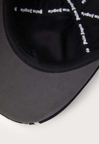 Black cap with a flat brim, made of smooth fabric. Interior lined with black material featuring printed white text along the band.