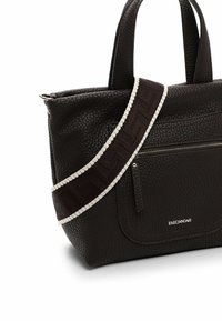 Braune, genarbte Leder-Handtasche mit zwei Griffen, ausgestattet mit einer Reißverschlusstasche und einem gemusterten, verstellbaren Schulterriemen. Weiße Akzentdetails sind vorhanden.