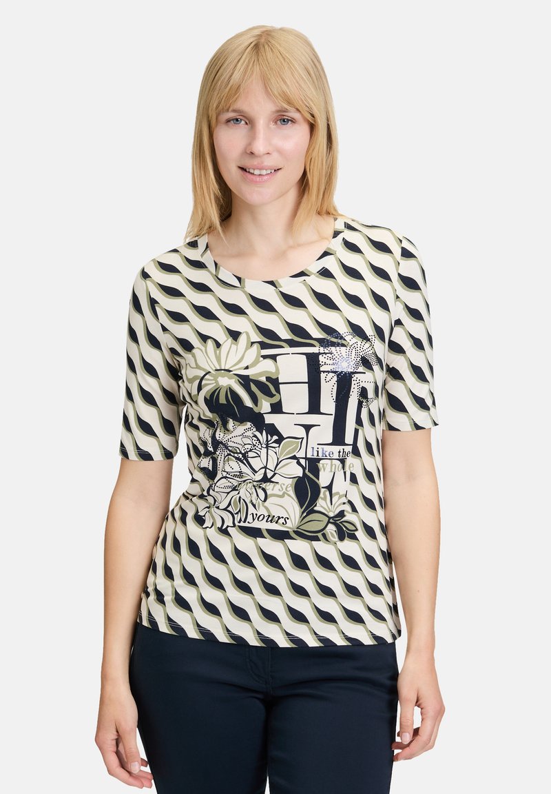 Short-sleeve cream top featuring navy wavy stripes, floral graphics, and printed text design. Smooth fabric with a round neckline.