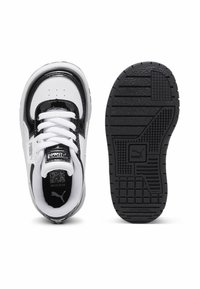 Białe i czarne sneakersy Puma dla dzieci z wiązaniem, pokazane z widoku z góry i podeszwy, z logo Puma na języku i podeszwie.