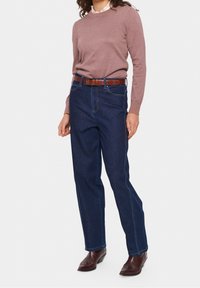 Denim jeans in dark blue with a straight-leg cut, paired with a light brown sweater. Features a brown textured belt and brown footwear.