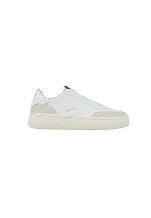 Hvid lavtop sneaker med beige accenter, tyk cremefarvet sål, snørebånd og "SMITH X" logo på siden.