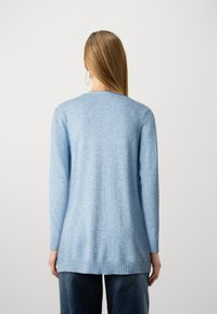 Pull bleu clair à manches longues en matière douce. Caractéristiques : ourlet et poignets côtelés. Design simple avec un col rond. Sans ornements.