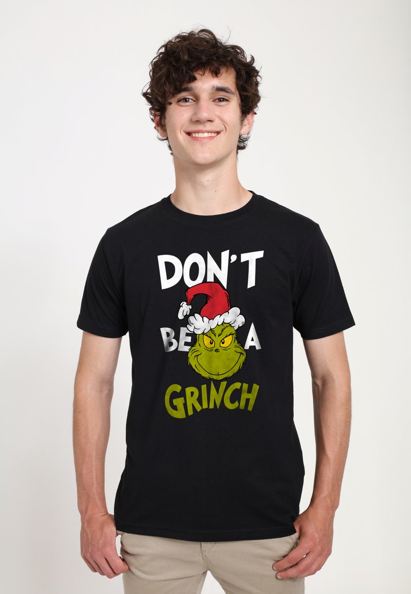 Černé bavlněné tričko s grafickým designem Grinche v santovské čepici. Text zní "NENÍ BUĎ GRINCH" tučnými bílými a zelenými písmeny.