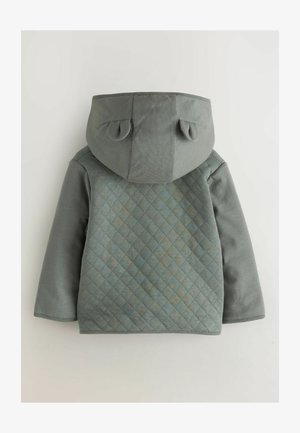 Kurtka pikowana w kolorze szarym z teksturowanym tyłem, płaskim kapturem i zaokrąglonymi uszami. Tkanina jest miękka, z gładkim przodem i wzorem w romby.