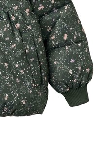 Manga de chaqueta de plumas verde con puño elástico, que presenta un estampado de flores rosas y moradas sobre un fondo de tejido texturizado.