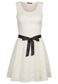 Biała sukienka z koronkowej tkaniny w kwiatowy wzór, z okrągłym dekoltem i bezrękawnikowym krojem, ozdobiona czarnym satynowym pasem zawiązywanym w kokardę w talii.