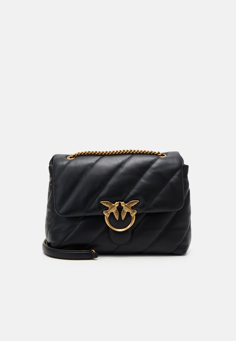 Zwarte leren handtas met een geblokt ontwerp, gouden kettingschouderriem en een decoratieve ring met twee vogelaccenten aan de voorkant.