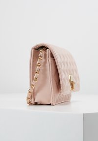 Borsa a tracolla in ecopelle rosa trapuntata con catena dorata, dotata di chiusura a risvolto magnetica e finitura liscia. Forma rettangolare compatta.