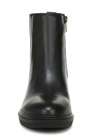 Zwarte enkelboot gemaakt van gestructureerd leer, met een gladde voorkant, ronde neus en een zijrits voor eenvoudig aan- en uittrekken.