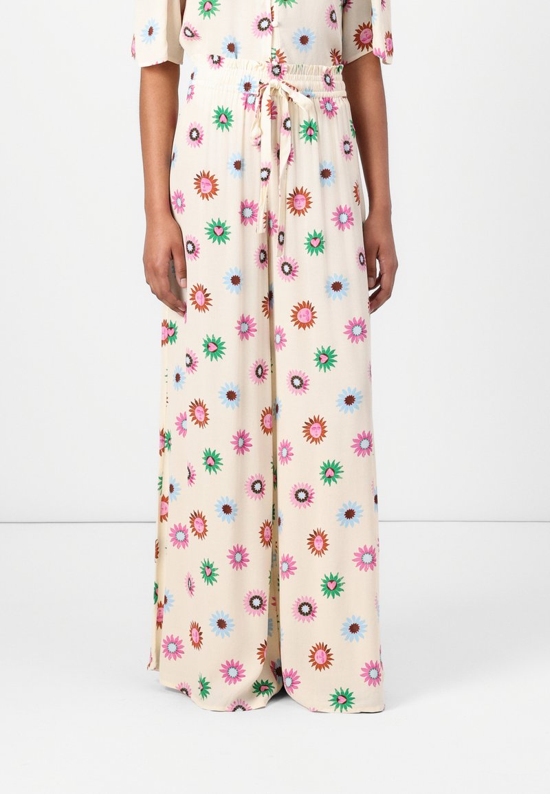 Wide-leg trousers with floral patterns in pink, blue, and green on a cream background; elastic waistband with a drawstring for adjustment.