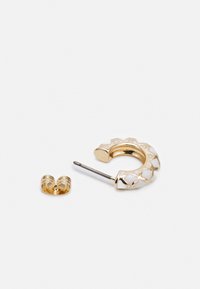 Os brincos de argola dourados apresentam um revestimento de esmalte branco com um padrão geométrico. Inclui um fecho dourado correspondente. A argola é circular e texturizada.