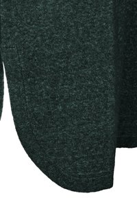 Tessuto verde scuro con una trama leggermente melangiata. Orlo arrotondato con dettagli in costina, che mettono in risalto un aspetto morbido e accogliente.