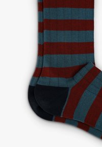 Calcetines a rayas con bandas alternas de rojo profundo y teal, con textura acanalada y acentos en azul oscuro en los dedos y los talones.