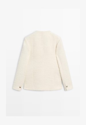 Witte textuurjas met een rechte snit, lange mouwen en een knoop aan de manchet. De achterkant heeft een subtiele verticale naaddetail.