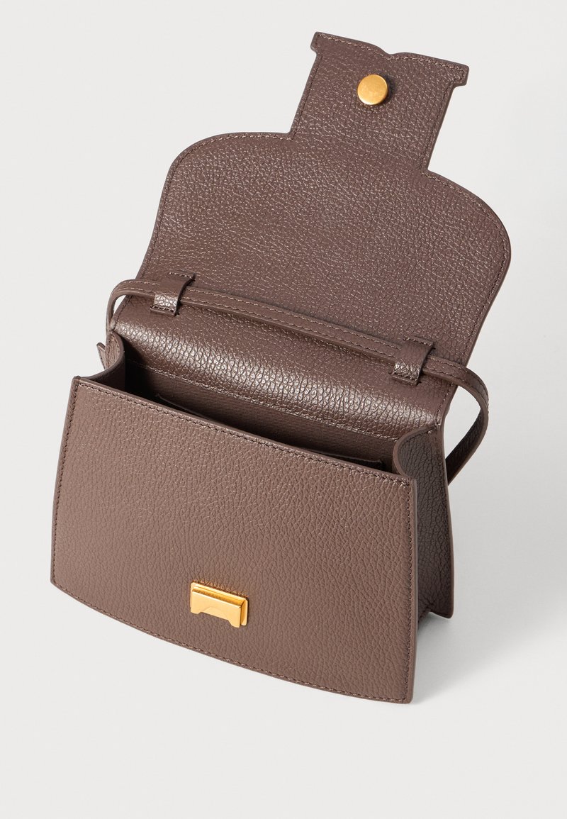 Sac à main en cuir marron avec une finition texturée, fermeture à rabat et quincaillerie dorée. Son design compact présente un compartiment principal ouvert.