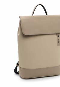 Zaino in pelle beige con chiusura a patta, manico superiore e spallacci neri regolabili. Texture liscia con un sottile dettaglio di cucitura e etichetta del logo.