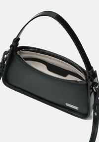 Borsa a mano in pelle nera con superficie liscia, chiusura con zip e manico corto. L'interno è foderato in tessuto beige e presenta uno slot per le carte.