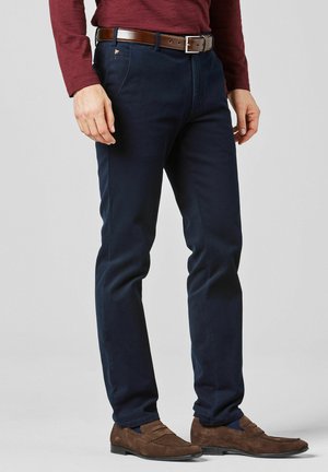 Man wearing navy blue trousers, brown suede loafers, a brown leather belt, and a burgundy long-sleeve shirt.