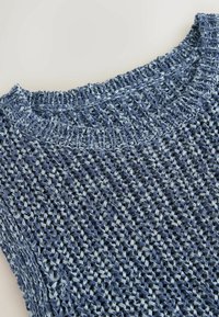 Haut sans manches bleu tricoté de manière lâche avec un col rond côtelé mettant en valeur un motif texturé à tissage ouvert et des tons de fil variés.