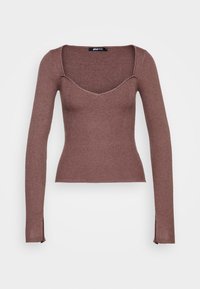 Brun, räfflad långärmad topp med fyrkantig halsringning, figurnära passform och sidoklyftor i fållen för extra detalj.