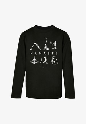 Black long-sleeve t-shirt featuring white skeleton yoga poses and the word "NAMASTE" in bold letters on the front. Cotton material.