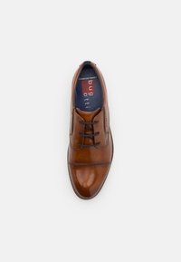Brown leather dress shoe with a polished finish, round toe, and decorative stitching. Features lace-up design and cushioned insole for comfort.