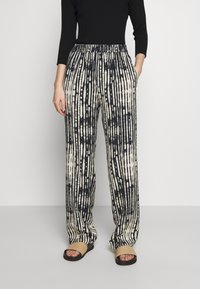 Kalhoty s širokými nohavicemi v černobílém pruhovaném vzoru, s elastickým pasem, volným střihem a bočními kapsami. Texturovaná látka.