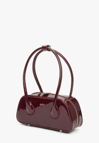 Bordeaux lakleren handtas met een gebogen ontwerp, twee schouderbanden en een zilveren ritssluiting. Heeft een logo aan de voorkant.