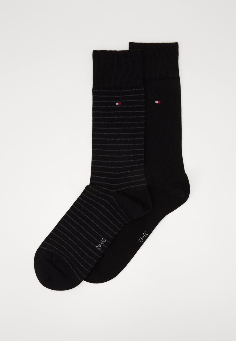 Deux paires de chaussettes : une noire unie et une noire avec de fines rayures. Mélange de coton, avec de petits logos de marque sur chacune.
