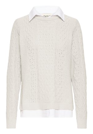 Krem pulover iz pletenega kabla z belo srajco s ovratnikom spodaj. Ima dolge rokave ter robove in spodnji del z rebrastim vzorcem. Teksturiran vzorec pletenja.