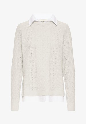 Flødefarvet kabelstrikket sweater med en hvid skjorte med krave under. Har lange ærmer samt ribstrikkede manchetter og kant. Tekstureret strikkemønster.