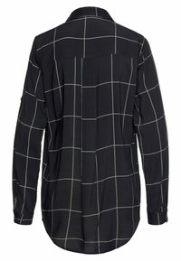 Must must sleeves, valge ruudustikuga särk, millel on seljaõmblus ja nööpdetailid varrukatel. Sile kangas.