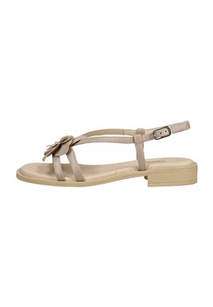 Sandalo piatto beige con cinturino alla caviglia, piccola fibbia e fiore decorativo sulle fasce anteriori, vista laterale.