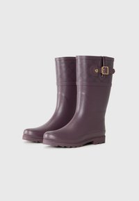 Bottes de pluie en caoutchouc violet avec une finition brillante, dotées d'une boucle décorative et d'un motif de logo en haut. Semelle texturée pour une meilleure adhérence.