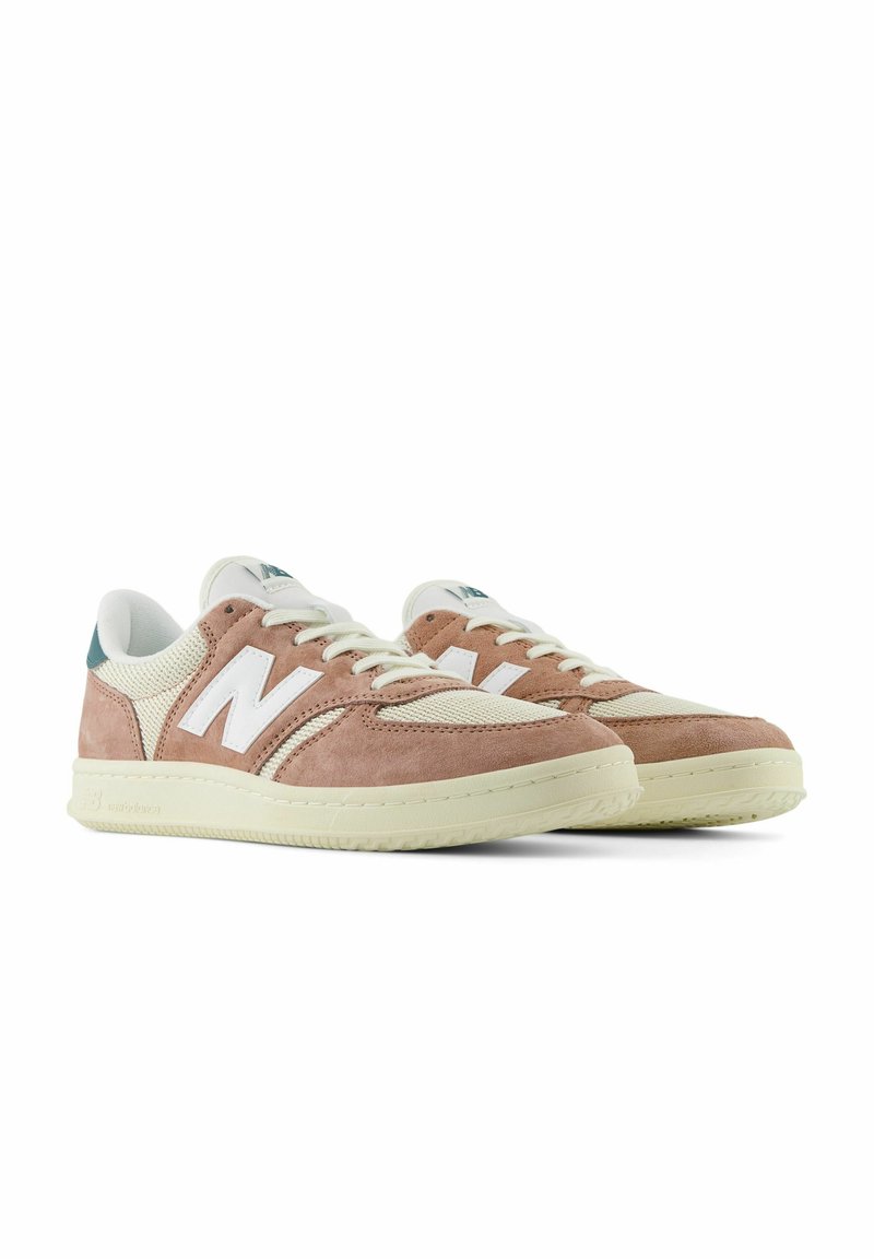 Zapatillas de ante rosa con acentos de malla blanca y una pestaña en el talón de color aguamarina. Presentan una parte superior suave y texturizada, y una suela gruesa de color crema.