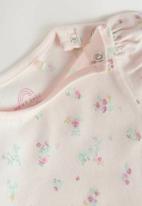 Puha rózsaszín baba body kis virágmintákkal és patentokkal a vállnál a könnyű öltöztetéshez.
