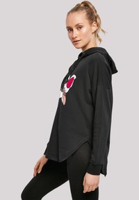 Black oversized hoodie with a drawstring, featuring a colorful cartoon character print on the front and a curved hem design.