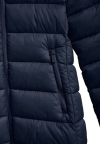 Mörkblå puffjacka med kviltad design, slät textur och en zip-ficka på vänster sida för säker förvaring.