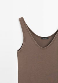Bruine katoenen tanktop met een ronde hals en dunne bandjes, met een geribbeld patroon. Label zichtbaar bij de halslijn.