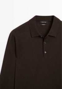 Bruin wollen polo shirt met een kraaghalslijn, drie knopen en een gladde textuur. Label toont de merknaam en materiaalsamenstelling.