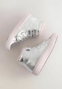 Metallisch silberne High-Top-Schuhe mit einem strukturierten Sternmuster, pinkem Kunstfellfutter und hellpinkfarbigen Gummisohlen; mit Klettverschluss.