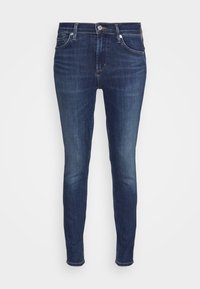 Jeans skinny azul oscuro con una cintura alta, cierre de botón y cremallera, y diseño de cinco bolsillos sobre un fondo blanco.