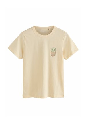 Hellgelbes T-Shirt mit kurzen Ärmeln aus Baumwolle, das auf der linken Brustseite ein kleines gesticktes Design eines Kuchens zeigt.