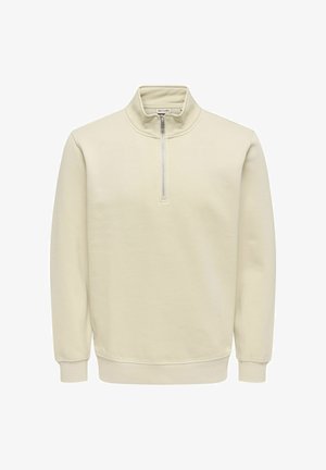 Vaaleanbeige svetari korkealla kauluksella, puolivetoketjulla edessä, pitkät hihat, resorit hihoissa ja helmassa, valmistettu sileästä kankaasta.