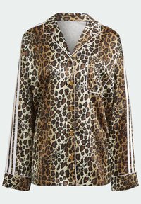 Leopardmönstrad pyjamaskjorta i satin med bruna och beige toner. Har vit kantning, långa ärmar och knäppning framtill. Stor bröstficka ingår.