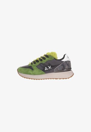 Zapatilla con gamuza verde, cuero negro, talón de camuflaje, forro de piel de lima, cordones negros, suela blanca y símbolos delta y X blancos en el lateral.